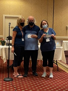 Board members Jan Cardia, Steve Pellinen, and Helen Flores with prize checks.